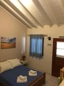 1 dormitorio con 1 cama con 2 toallas en Gregory's Village, en Plati