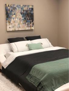 a bedroom with a large white bed with a painting on the wall at Casa de Férias in Villa Nogueira