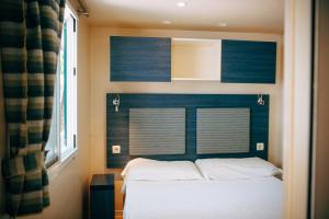 a bedroom with a bed with a blue wall at Camping Wien in Peschiera del Garda