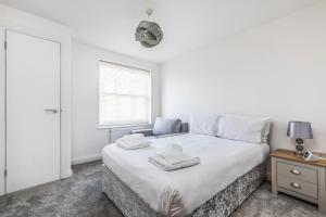 Un dormitorio blanco con una cama con toallas. en Seafront 2 Bedroom Apartment, en Portsmouth 10 fotos más