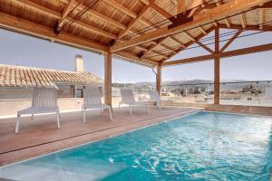 a swimming pool with chairs on a wooden deck at Sercotel Granada Suites in Granada