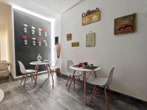 ein Esszimmer mit 2 Tischen, Stühlen und einer Tafel in der Unterkunft Domus Rubra in Castelsardo