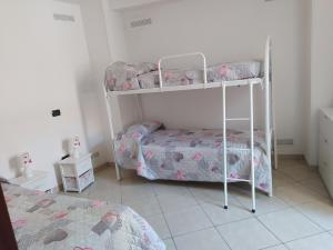 a bedroom with two bunk beds and a bed at Estìa Casa Vacanze in Scilla