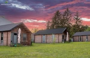 Ein paar Häuser auf einem Feld mit Sonnenuntergang in der Unterkunft Przystań Piława in Borne Sulinowo
