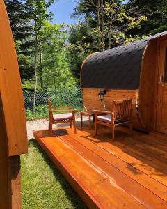 dos bancos sentados en una cubierta en una cabaña en Campeggio il Bosco, en Entracque