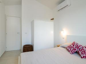 una camera da letto con un letto con cuscini rossi e bianchi di Country Lodge - Klodge a Olbia