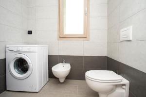 Un baño con lavadora y un inodoro. en Dimora Mascagni - Goelba, en Portoferraio