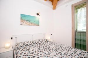 Una habitación blanca con una cama y una ventana en Dimora Mascagni - Goelba, en Portoferraio