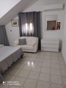 - une chambre avec un lit et un canapé blanc dans l'établissement La casa di Anna, à Grisolia