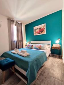 a bedroom with a large bed with a blue wall at Domus Rubra in Castelsardo