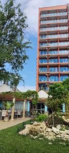 a tall building with a garden in front of it at Hotel Shipka Beach - Free parking in Sunny Beach