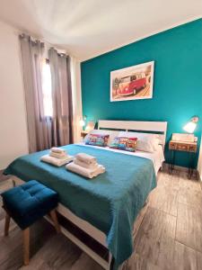 niebieska sypialnia z łóżkiem z ręcznikami w obiekcie Domus Rubra w mieście Castelsardo
