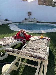 een bed en een tafel naast een zwembad bij La Casa De La Abuela in Setenil