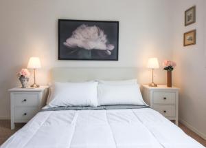 1 dormitorio con 1 cama blanca y 2 mesitas de noche en Apartments Florence - Florentine Skyline en Florence