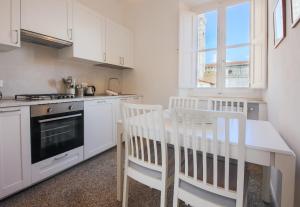 cocina con armarios blancos, mesa y sillas en Apartments Florence - Florentine Skyline en Florencia
