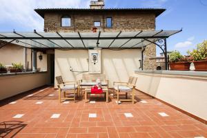 un patio con mesa y sillas en la azotea en Apartments Florence - Florentine Skyline en Florencia