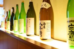 a row of wine bottles sitting on a shelf at Oishiya in Ise