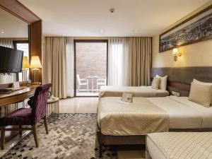 ein Hotelzimmer mit zwei Betten und einem Schreibtisch in der Unterkunft Nowy Efendi Hotel - Special Category in Istanbul