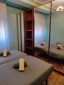 Zimmer mit 2 Betten und einem Spiegel in der Unterkunft A&C PLAZA HARO in Haro