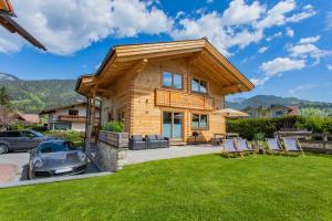 a log home with a car parked in the yard at Chalet Huber by Alpenidyll Apartments in Aich