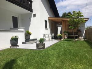 un patio trasero con césped verde y una casa blanca en Ferienwohnungen Veronika Wohnung 1 en Mittenwald