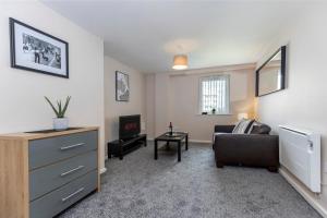 a living room with a couch and a tv at Oakstays Gateshead in Gateshead