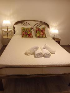 1 cama con 2 toallas blancas y 2 lámparas en Casita da Floresta, en Ferreira do Zêzere