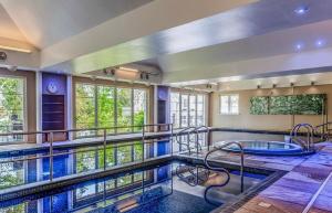 a large swimming pool with a hot tub at Ryder Cup Lodge Duchally - Free access to Leisure Club Swimming Pool Hot Tub Steam Room and Gym - Starlink Satellite Internet - Sky Glass Now DOG FRIENDLY for 2024 in Auchterarder