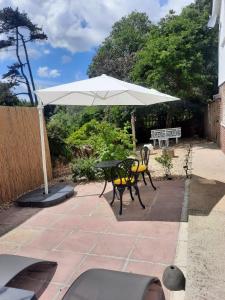 a table with a white umbrella on a patio at Woodside Annexe in Paignton