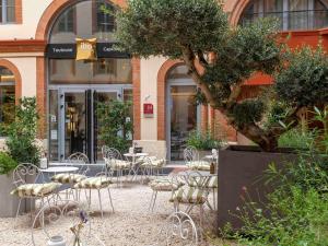 Ibis Styles Toulouse Capitole في تولوز: مجموعة من الكراسي والطاولات أمام المبنى