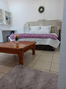 a bedroom with a bed and a coffee table at Danodeb Lodge in Pietermaritzburg