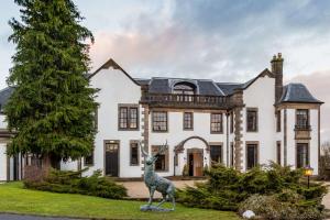 uma estátua de uma girafa em frente a uma casa em Gleddoch Golf & Spa Resort em Langbank