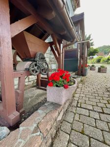 un patio con fiori rossi in una scatola di pietra di Landhotel Traube a Baden-Baden