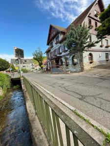 eine Brücke über einen Fluss neben einem Gebäude in der Unterkunft Landhotel Traube in Baden-Baden