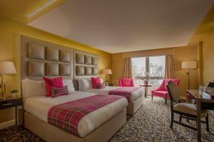 2 camas en una habitación de hotel con detalles en color rosa en Gleddoch Golf & Spa Resort, en Langbank