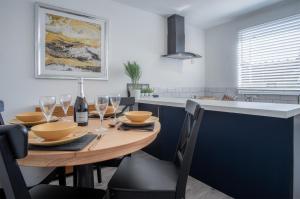 a kitchen with a wooden table with wine glasses at Ivy Cellar - 2 Bedroom Apartment - Tenby in Tenby