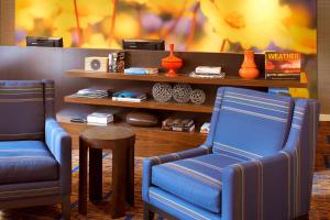 dwa niebieskie krzesła i stołek w pokoju w obiekcie Sonesta Select Detroit Auburn Hills w mieście Auburn Hills