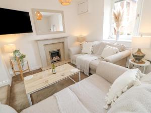 sala de estar con 2 sofás y chimenea en Ploughmans Cottage en Brampton