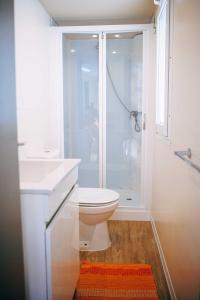 a white bathroom with a toilet and a shower at Camping Wien in Peschiera del Garda