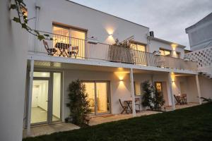 Casa blanca con balcón, mesa y sillas en Casas do Portinho, en Marinha Grande