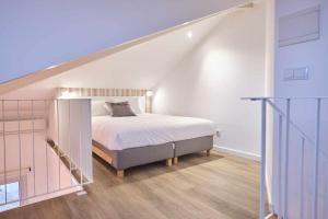 1 dormitorio blanco con 1 cama en el ático en Casas do Portinho, en Marinha Grande