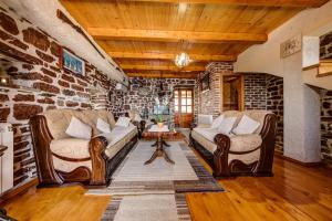 a living room with two couches and a stone wall at Old Stone House Villas in Tivat
