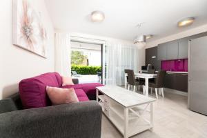 a living room with a purple couch and a table at Waterfront Apartments Pia - Marija in Malinska