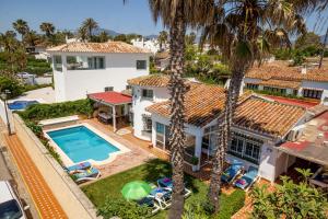 an aerial view of a house with a swimming pool and palm trees at Villa Ruby by Villa Plus in Estepona