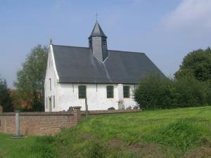 uma velha igreja branca com um campanário numa colina em B&B Sint Blasius Hof em Zwalm