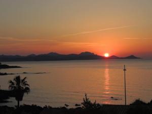 un tramonto su un corpo d'acqua con mulino a vento di T3 Les Issambres vue mer. Vélos, paddles sur place a Les Issambres