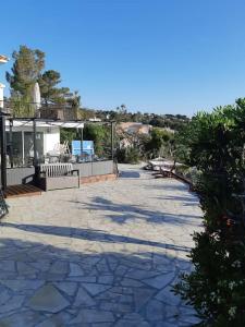 un patio in pietra con panchine e una casa di T3 Les Issambres vue mer. Vélos, paddles sur place a Les Issambres