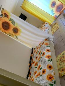2 Etagenbetten in einem Zimmer mit Sonnenblumenlaken in der Unterkunft Carpe Diem in Jumet