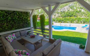 a patio with a couch and a table and a pool at Vacation Home My Dream in Buna