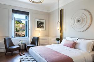 a bedroom with a bed and two chairs and a window at A77 Suites in Athens